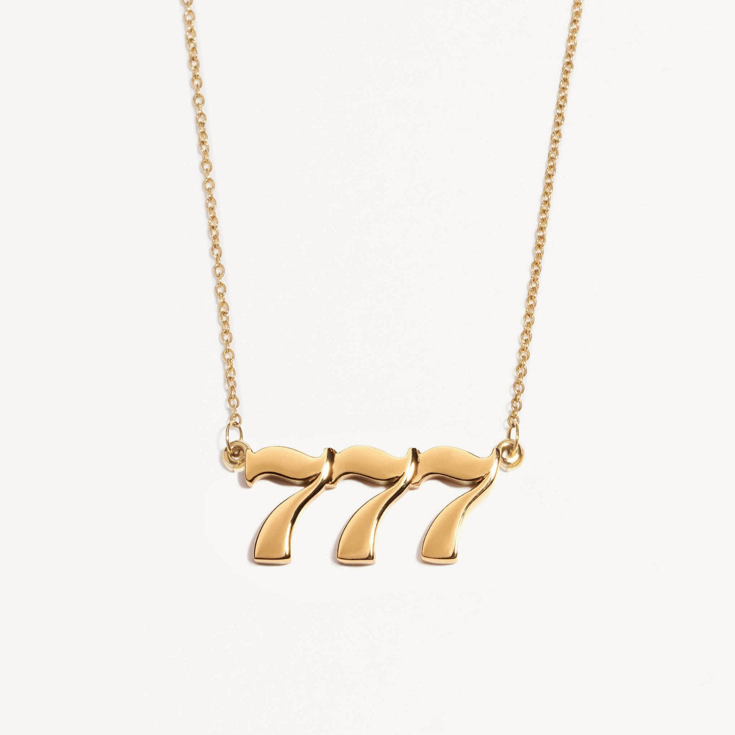 Gold necklace with a unique angel number 777 pendant on a white background