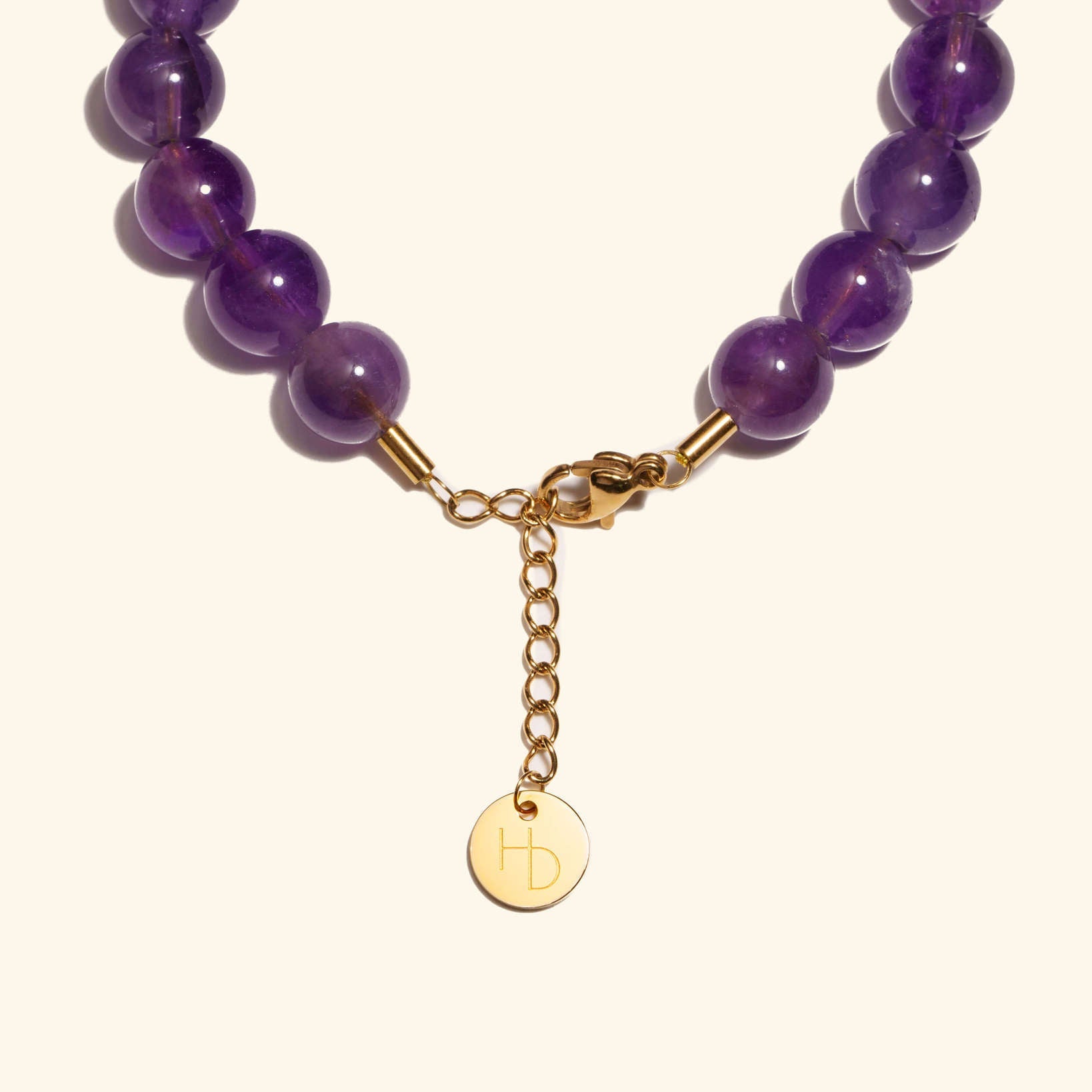 Amethyst charm bracelet close up showing the adjustable length extender and clasp