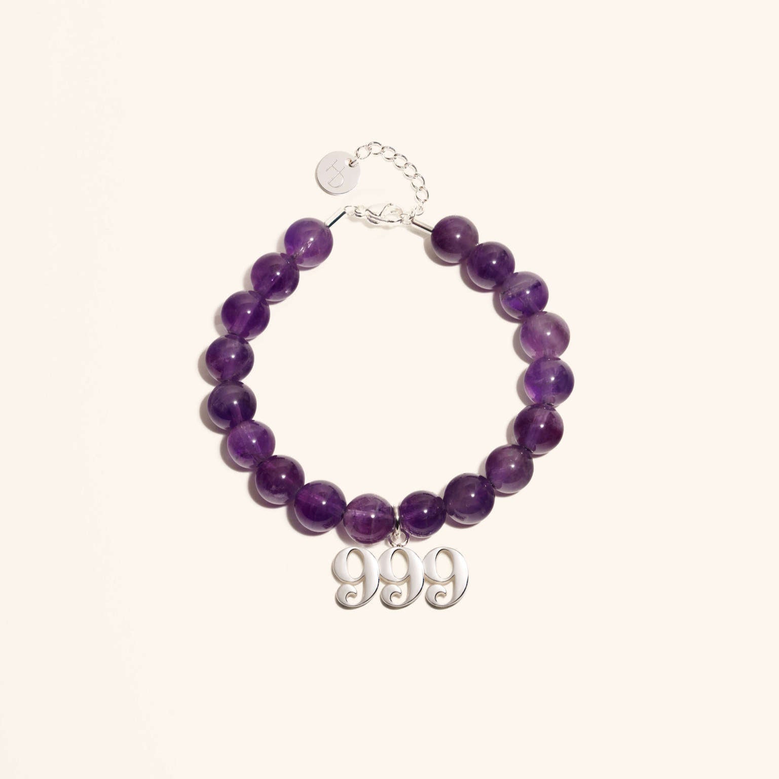 An Amethyst gemstone bracelet with a silver 999 Angel Number charm, featuring a series of purple beads and a stainless steel chain.