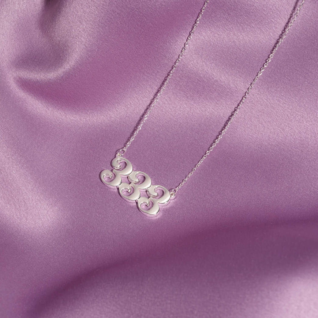 silver 333 necklace with unique design on silk