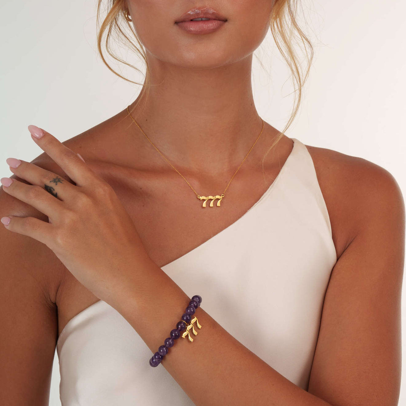 Model wearing a 777 gold bracelet with a matching 777 gold necklace
