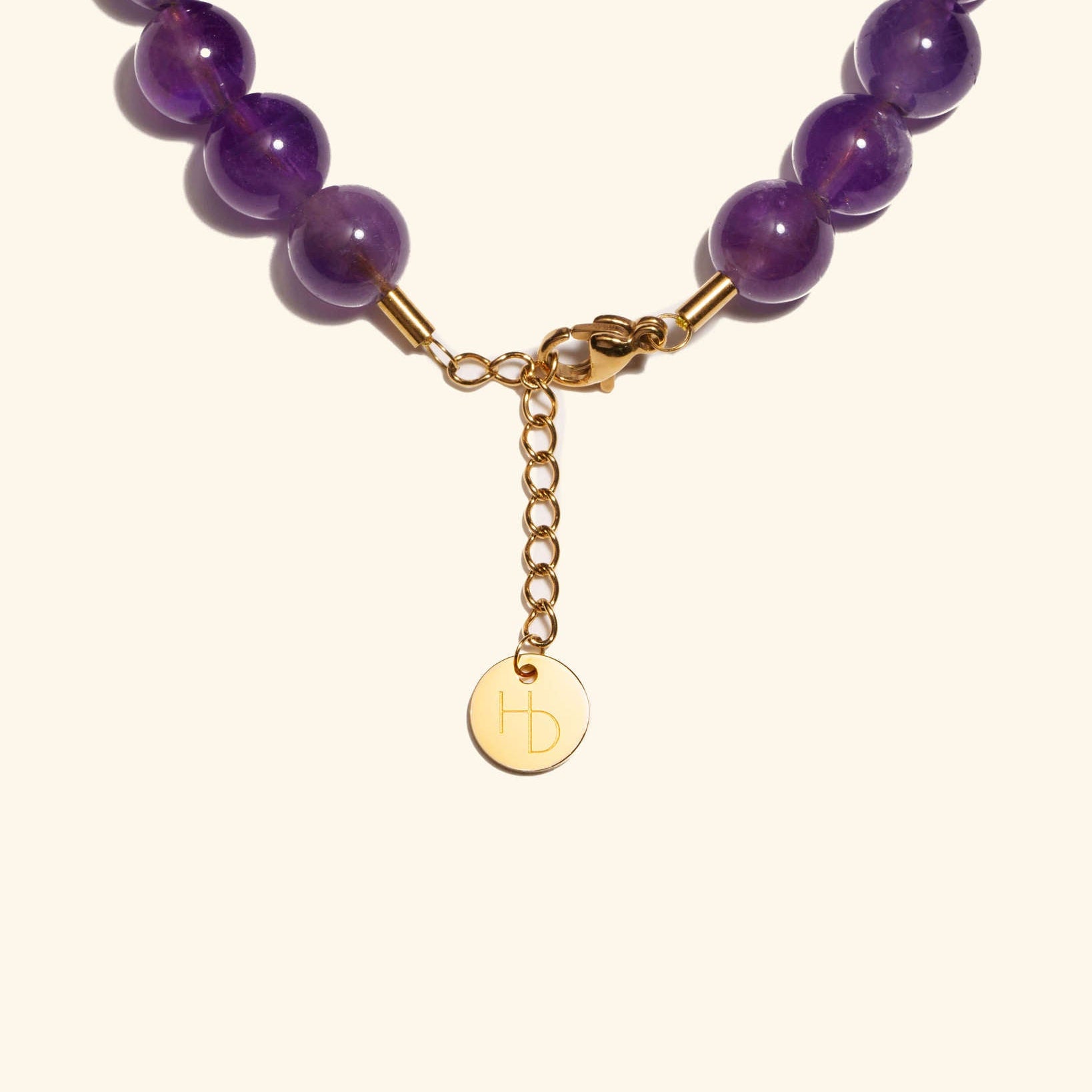 Amethyst charm bracelet close up showing the adjustable length extender and clasp