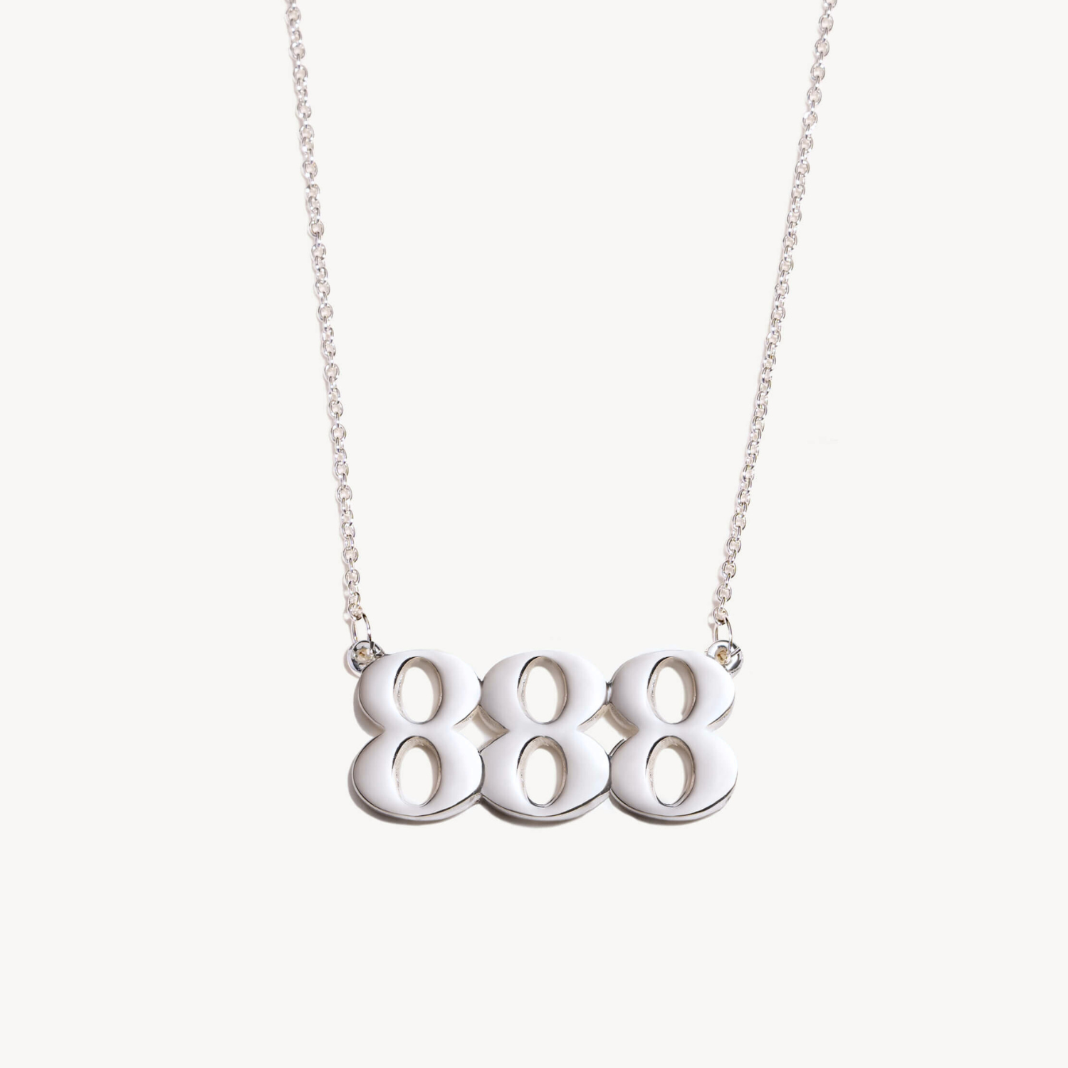 Silver necklace with three '8' charms 888 on a white background