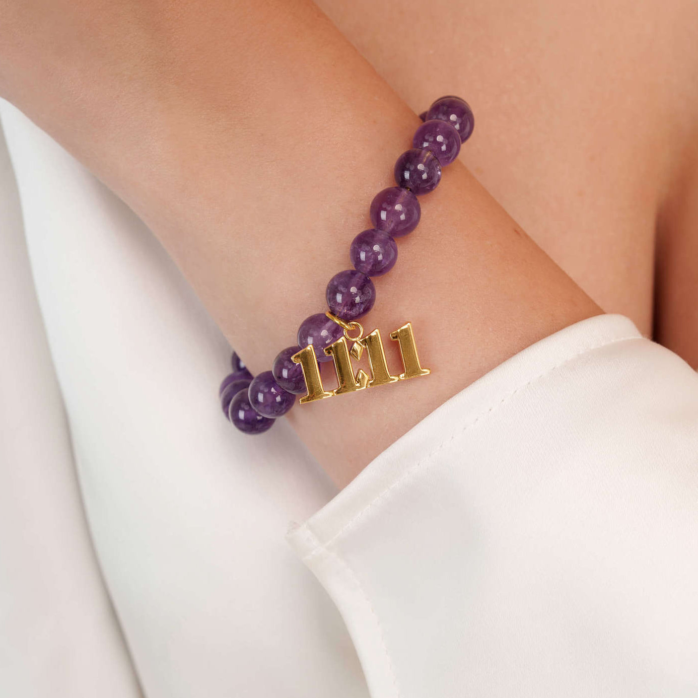 High quality purple amethyst beads with dangling 11:11 gold charm on wrist
