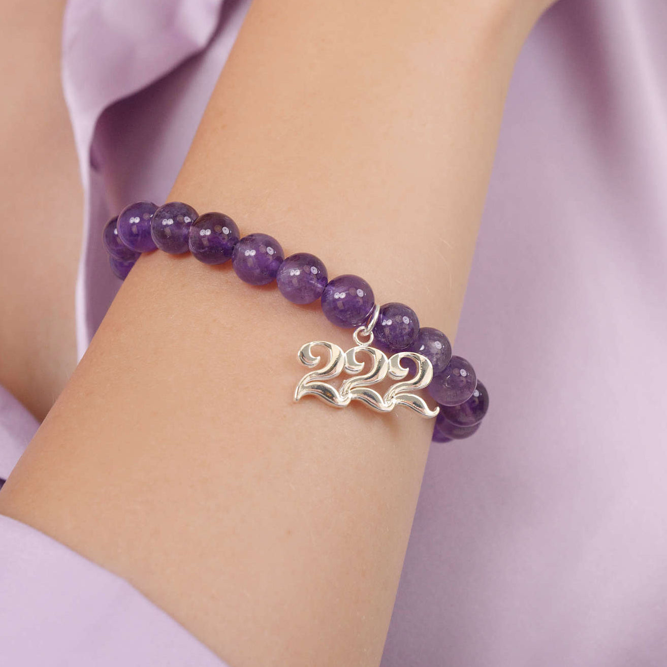 High quality purple amethyst beads with dangling 222 Silver charm on wrist
