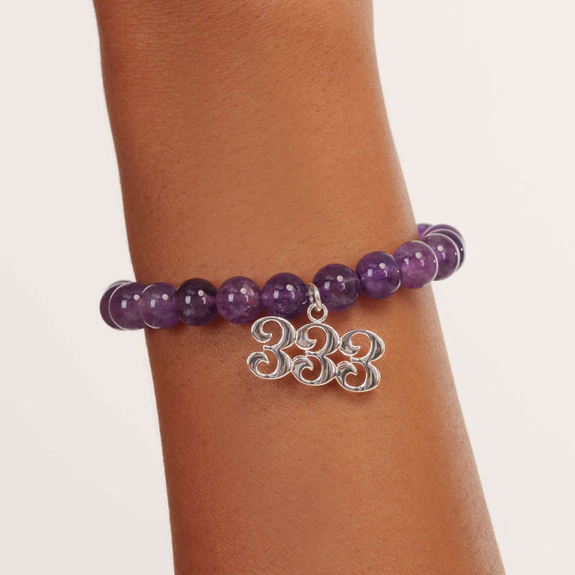 High quality purple amethyst beads with dangling 333 Silver charm on wrist