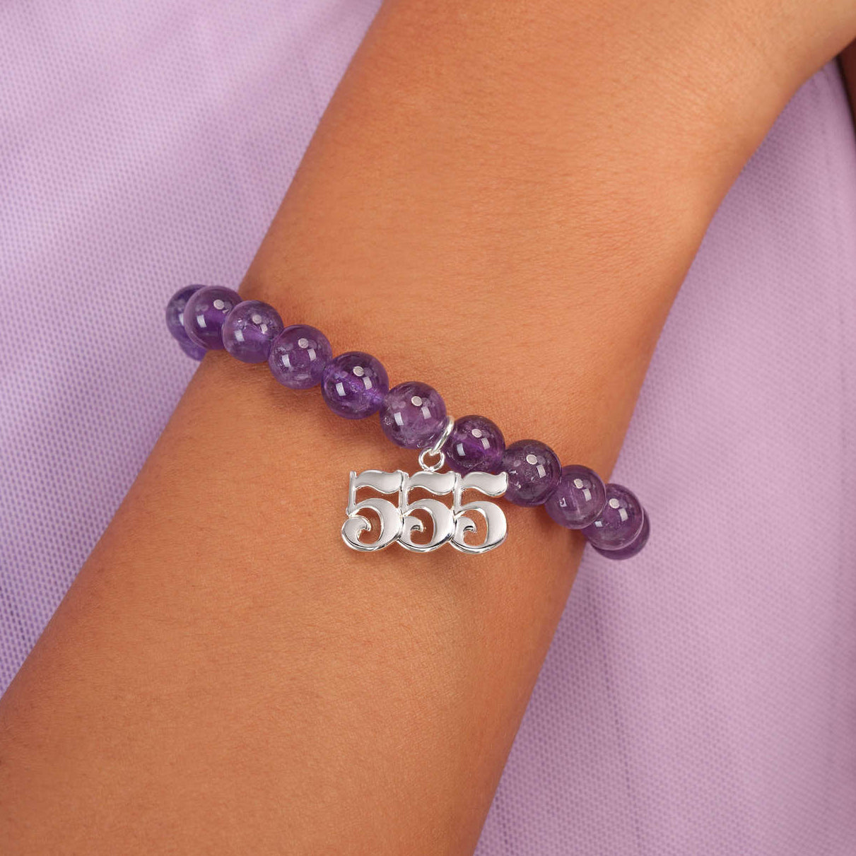 High quality purple amethyst beads with dangling 555 silver charm on wrist
