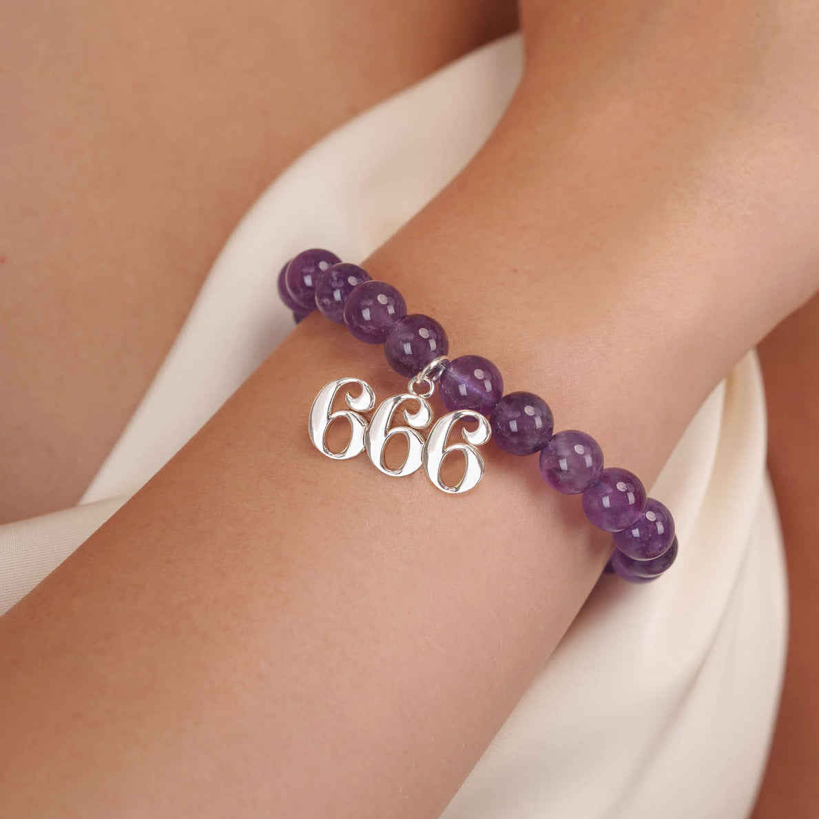 High quality purple amethyst beads with dangling 666 Silver charm on wrist
