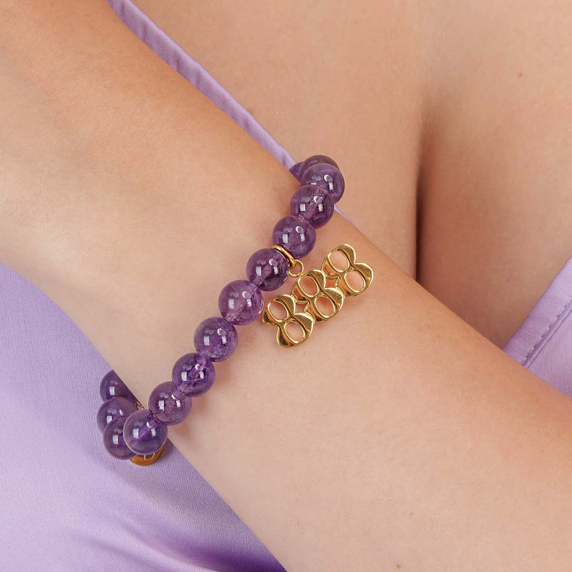 High quality purple amethyst beads with dangling 888 gold charm on wrist
