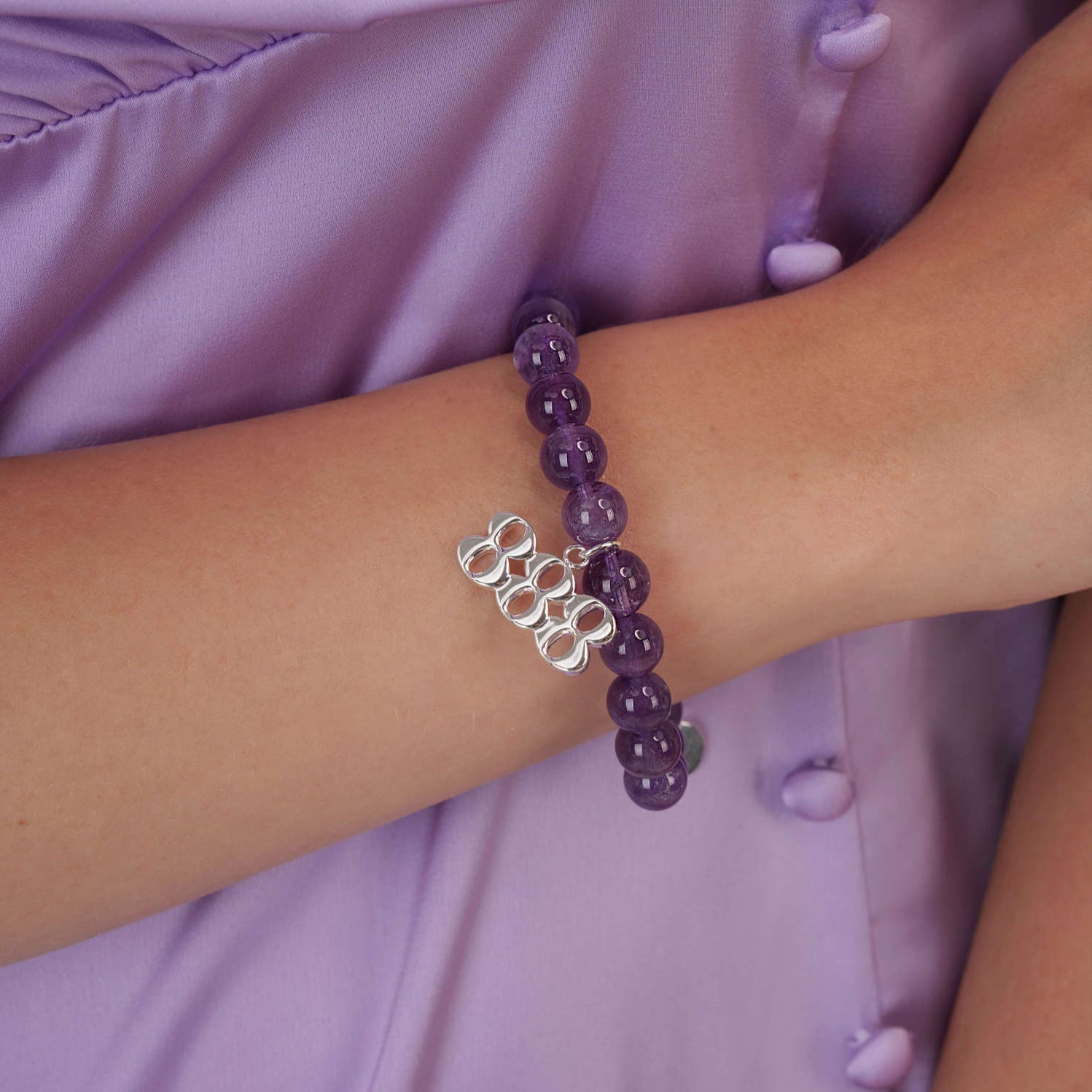 High quality purple amethyst beads with dangling 888 Silver charm on wrist
