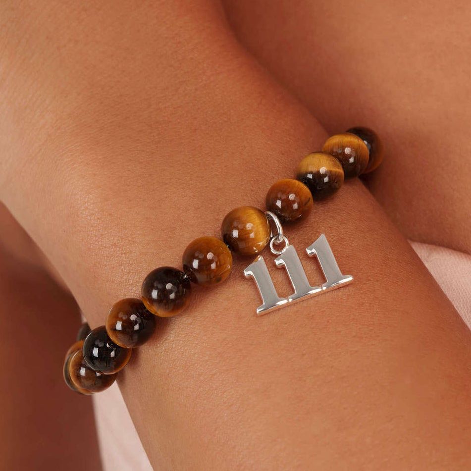 High quality Tigers Eye beads with dangling 111 Silver charm on wrist
