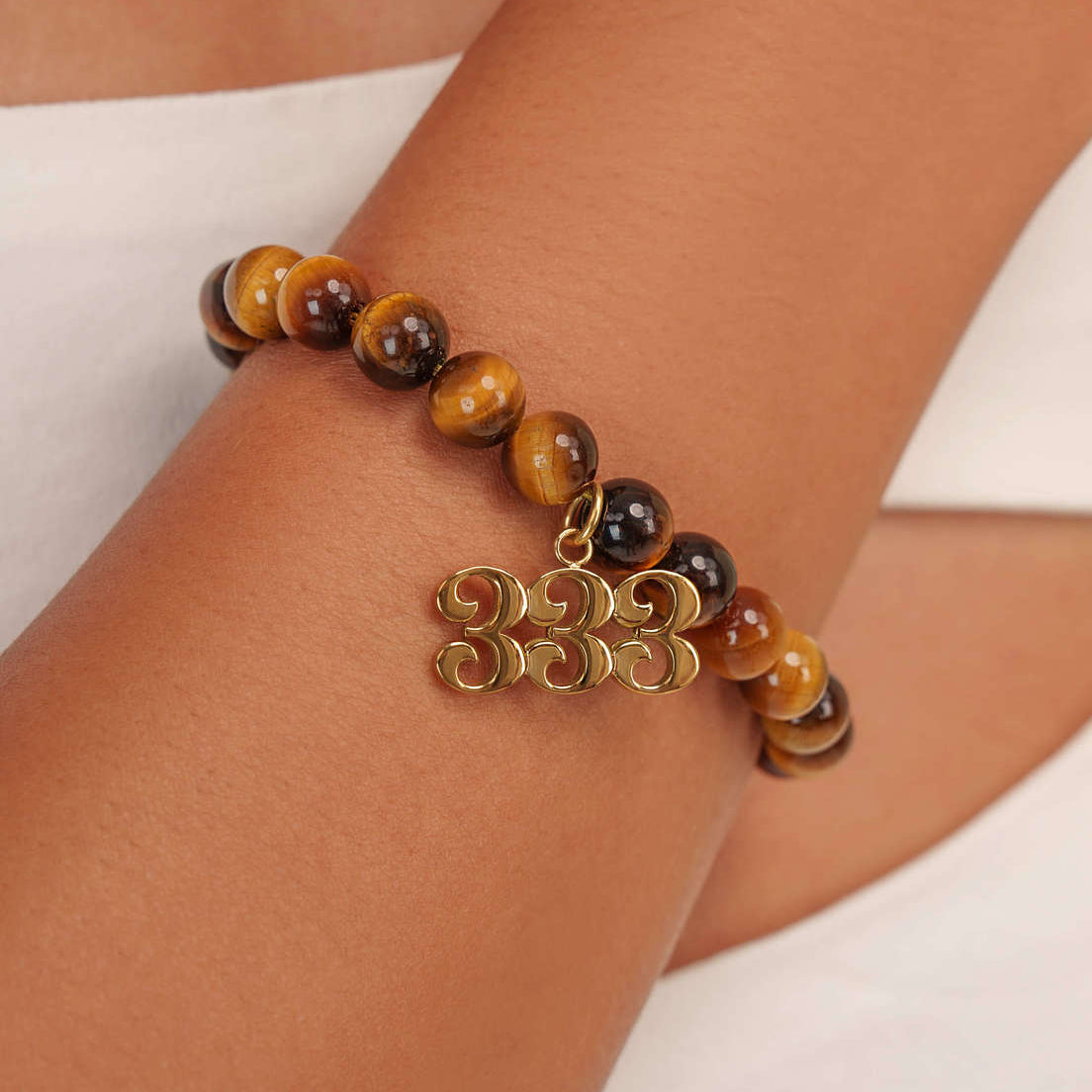 High quality Tigers Eye beads with dangling 333 Gold charm on wrist

