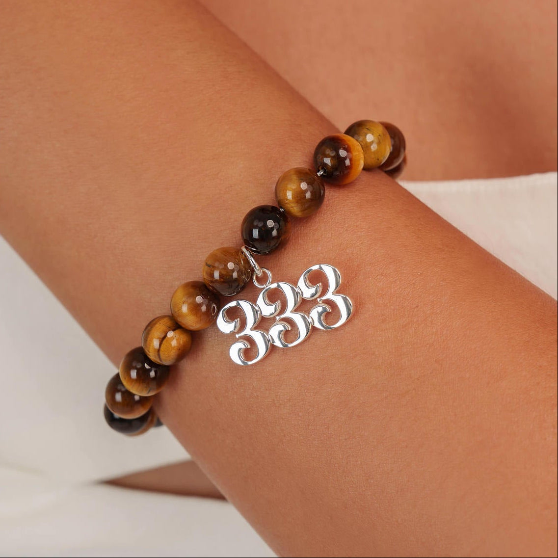 High quality Tigers Eye beads with dangling 333 Silver charm on wrist
