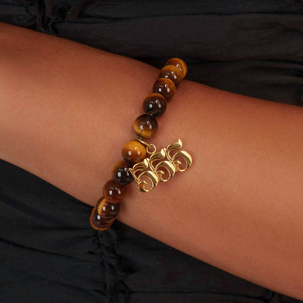 High quality Tigers Eye beads with dangling 555 Gold charm on wrist
