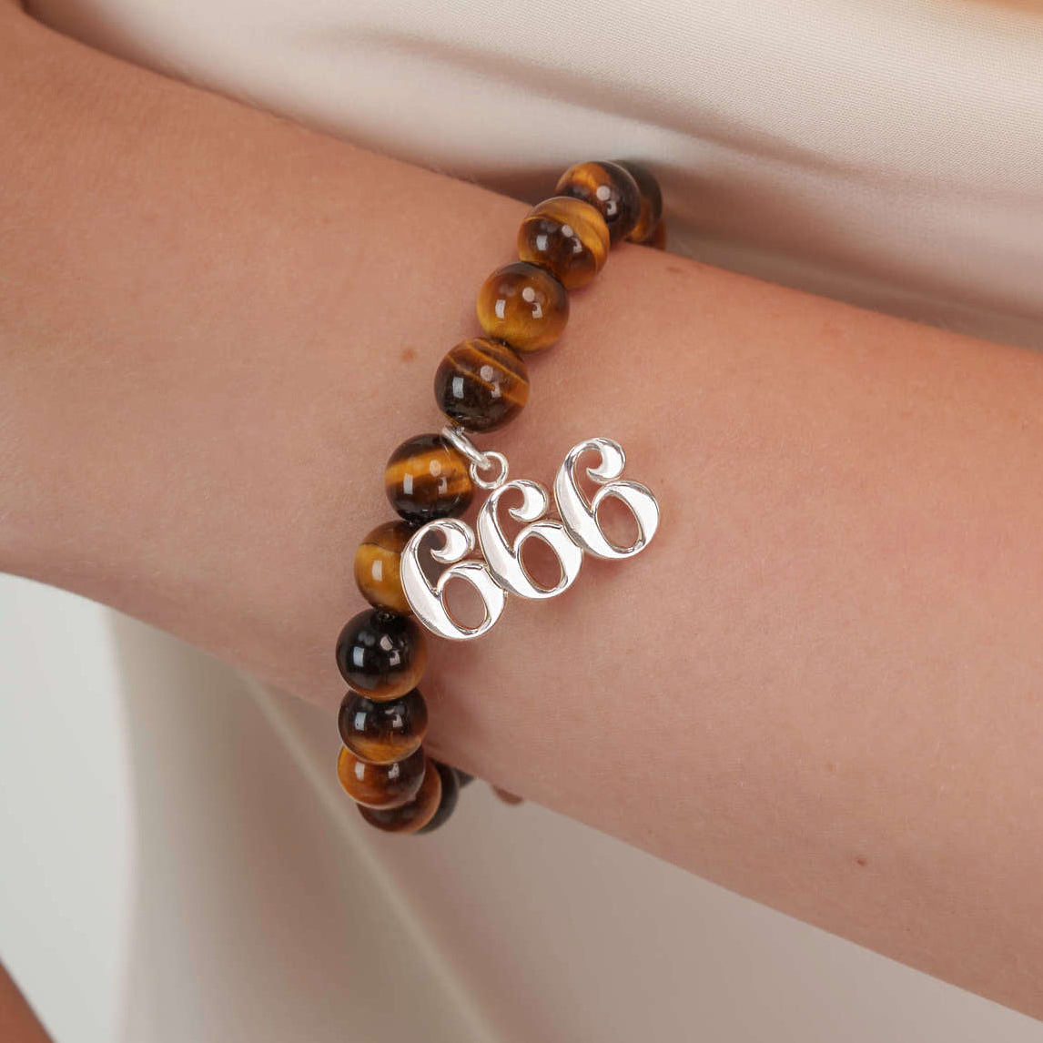 High quality Tigers Eye beads with dangling 666 Silver charm on wrist
