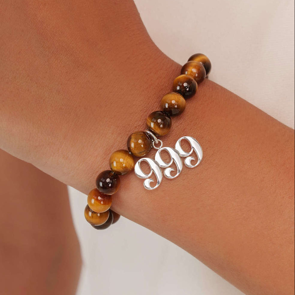 High quality Tigers Eye beads with dangling 999 Silver charm on wrist
