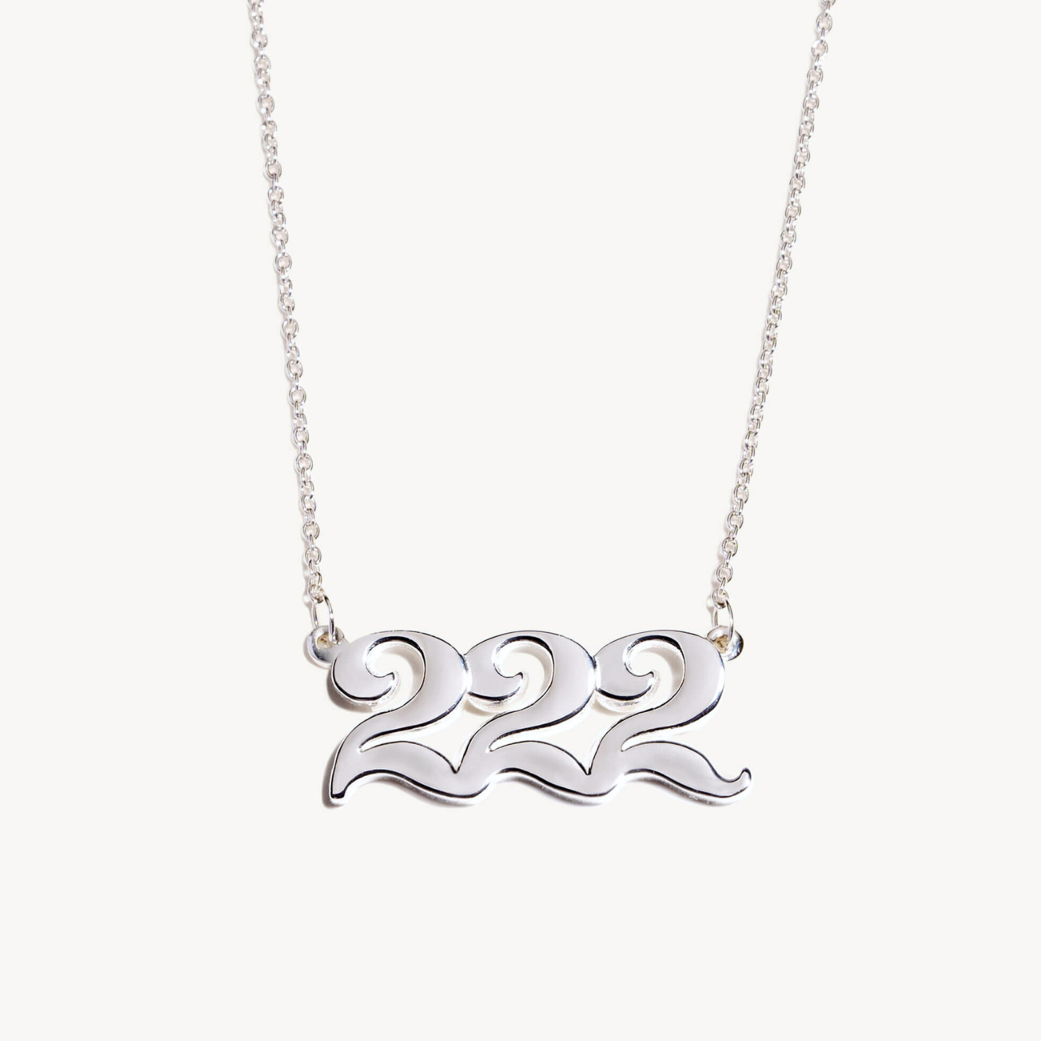Silver necklace with '222' design on a white background
