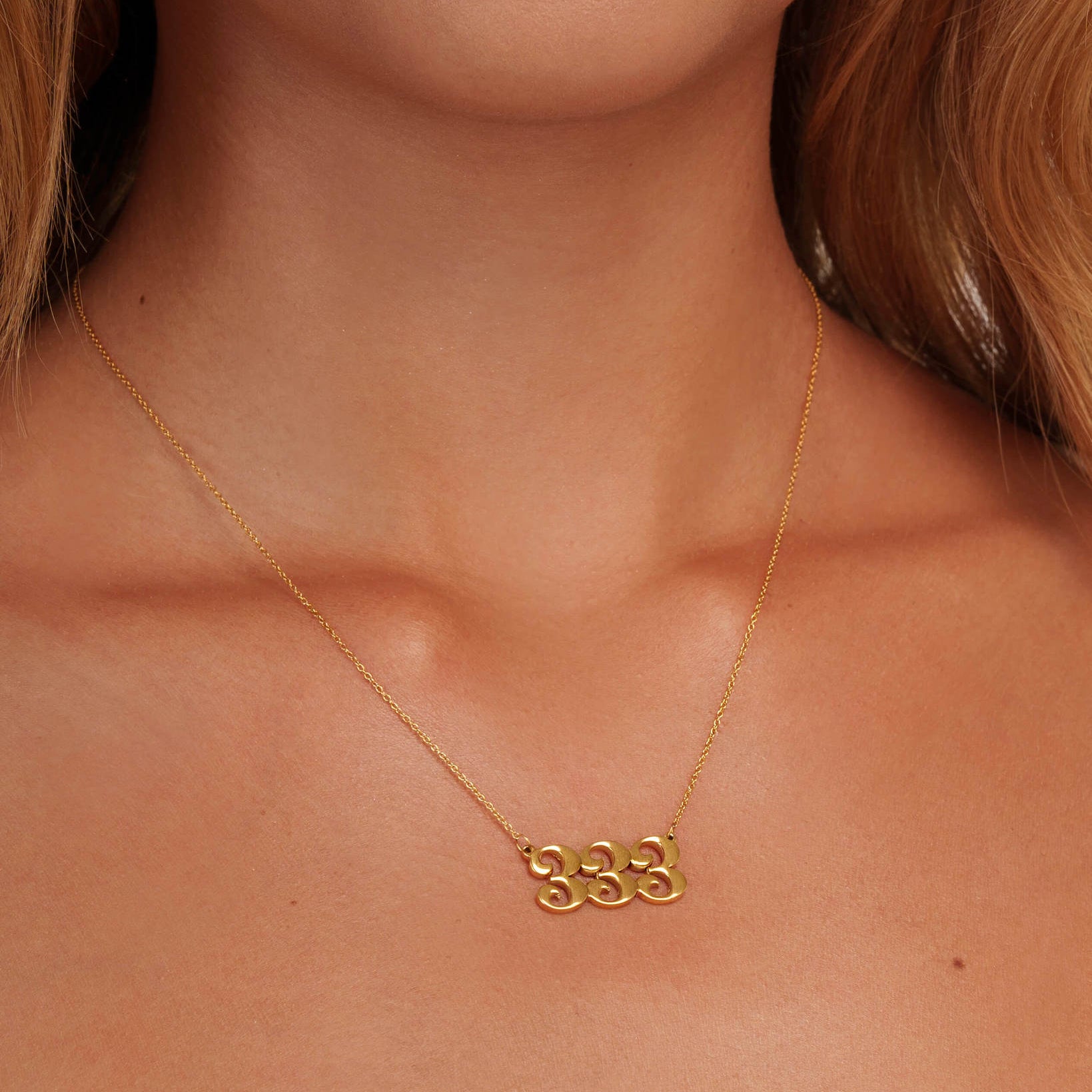gold 333 angel number necklace on neck